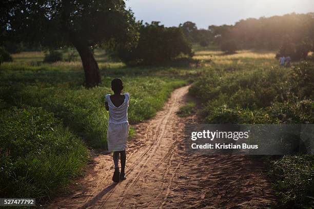 Girl heads home in the dying light in the evening in rural Makurdi in Benue State, Nigeria.Benue state has got one of the highest HIV prevalence in...