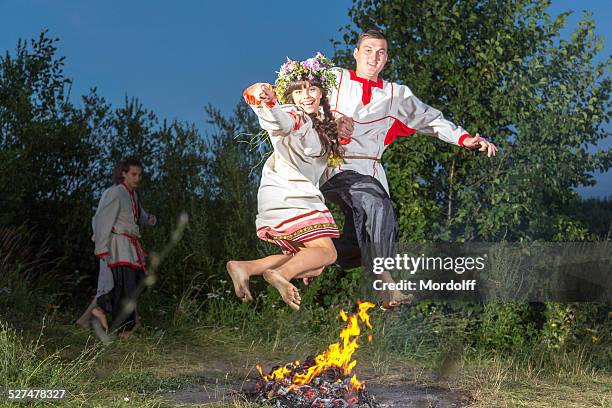 engraçado pulando fogueira no folk feriado - mid summer fire - fotografias e filmes do acervo