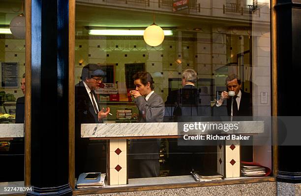 Businessmen sip morning coffee in one of the many cafes in the financial district of the capital called the Square Mile, also the oldest area of...