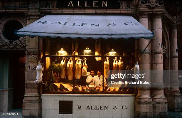 Portrait of two butchers standing in the window of R Allen & Co, Mayfair, London, the oldest and finest butchers in the capital. It is dawn one...