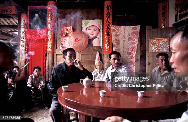 Wu Jian Xin with villagers in a private home discuss the order of events over the three day Hakka festivities, during the Buddhist religious,...