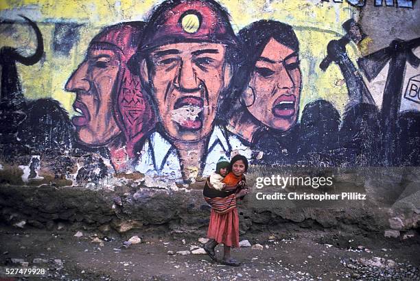 Young girl carries her baby brother in the town of Siglo XX tin mine, Llallagua, Bolivia | Location: Llallagua town, Bolivia.