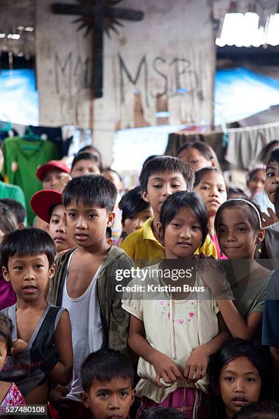 Children perform as part of a work shop on human trafficking in a Manila slum. Because of poverty and lack of income children and young women are...