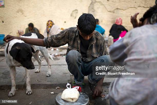 Homeless man with a stray dog by the side of the road at a temporary shelter in Karol Bagh, New Delhi, India
