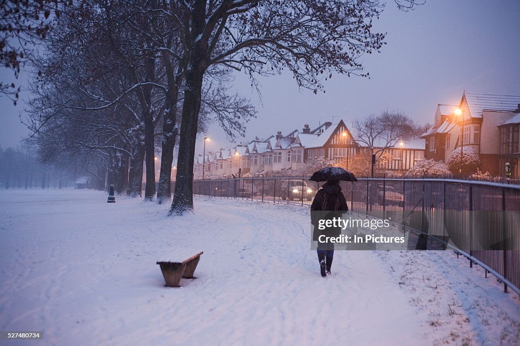 UK - London - Commuter walks through snowy park