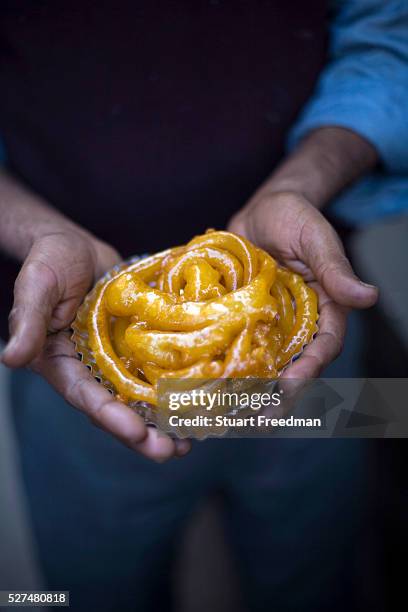 Man holds jalebis at the Old & Famous Jalebi Wala . Delhi, India