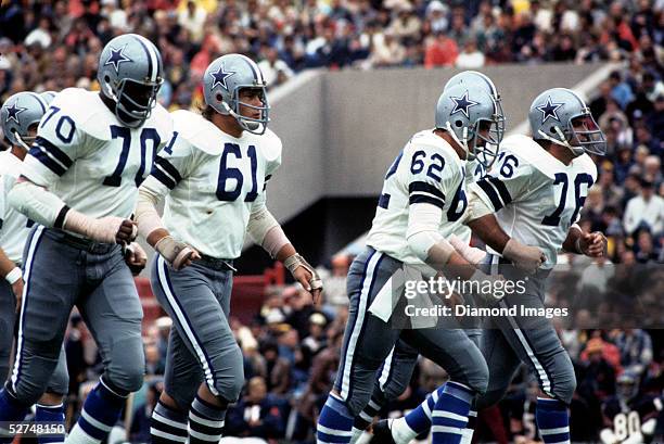 Offensive lineman Rayfield Wright, Blaine Nye, John Fitzgerald and John Niland, of the Dallas Cowboys, jog to the line of scrimmage for the next play...