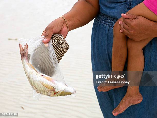 Woman and her daughter buy fish directly from the fishermen, Talisay, Santa Fe, Bantayan Island, The Philippines. On November 6 2013 Typhoon Haiyan...