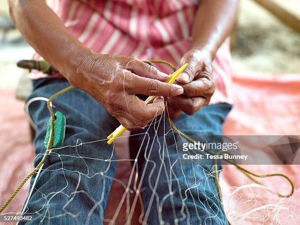 Gloria Mandawe repairs her husband's fishing nets, Tamiao, Bantayan Island, The Philippines. On November 6 2013 Typhoon Haiyan hit the Philippines...