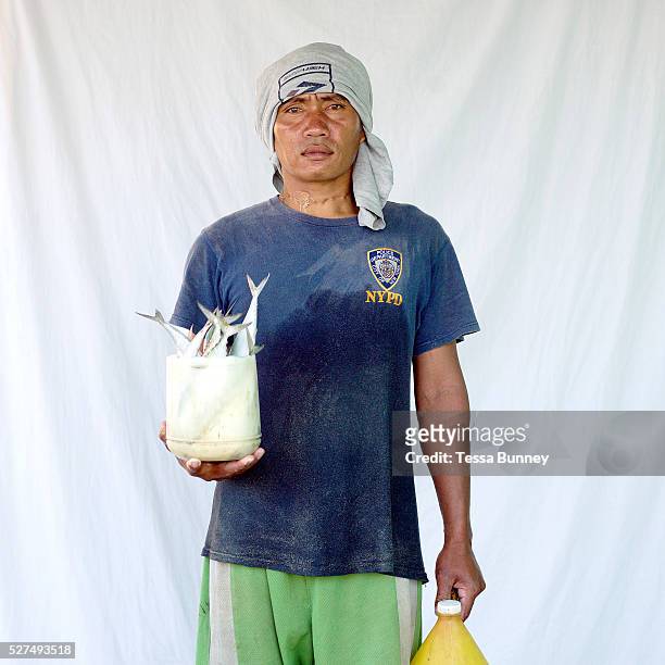 Dante Batuhan , fisherman with his catch, Pooc, Bantayan Island, The Philippines. Every morning at 7 am fisherwomen meet fishermen as they return...