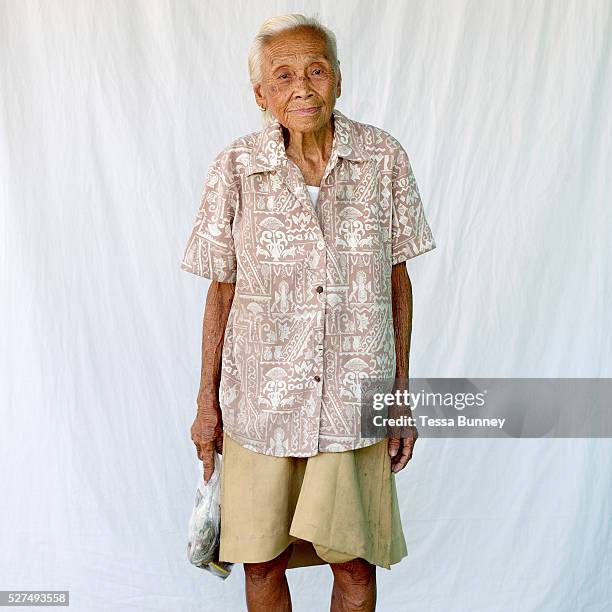 Rosario Amoco , retired, purchasing fish, Pooc, Bantayan Island, The Philippines. Every morning at 7 am fisherwomen meet fishermen as they return...