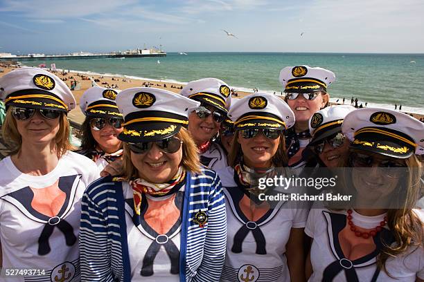 Group of young Scottish women gather for a portrait on Brighton seafront during their Hen weekend. One of their number is soon to be married and they...