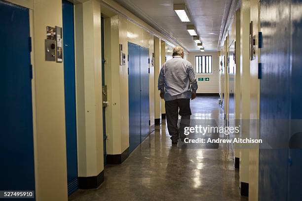 An elderly prisoner walking down the wing corridor. HMP & YOI Littlehey. Littlehey is a purpose build category C prison.