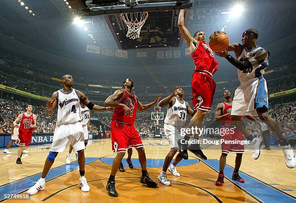 Larry Hughes of the Washington Wizards looks to dish the ball to an open teammate in the face of defensive pressure from Tyson Chandler of the...