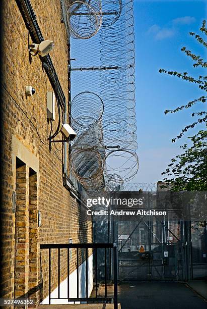 Security measures around the outside of one of the wings at HMP Wandsworth, including barbed wire and fencing. London, United Kingdom.