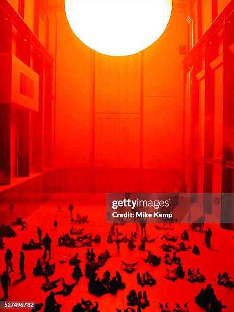 Public interact with the Weather Project by Danish artist Olafur Eliasson at Tate Modern. In this installation, representations of the sun and sky...