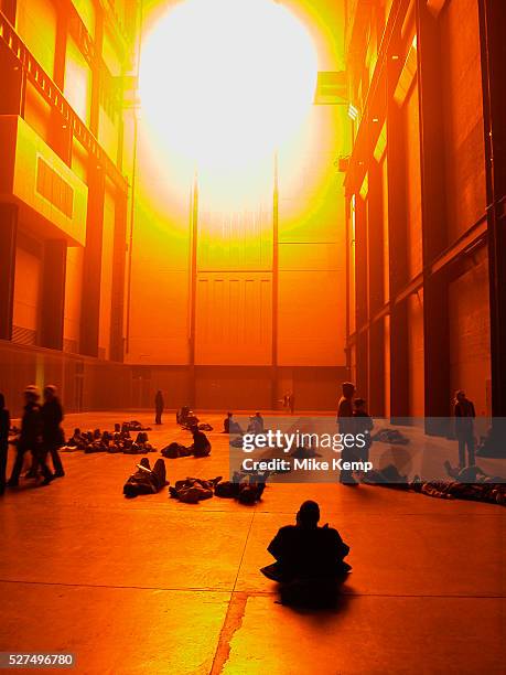 Public interact with the Weather Project by Danish artist Olafur Eliasson at Tate Modern. In this installation, representations of the sun and sky...