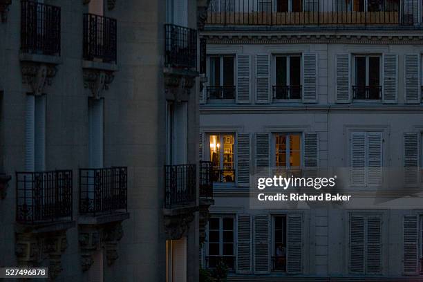 Evening light from apartment rooms glowing on the rue Navarin, 9th Arrondissement, Paris, France. Seen from down the street in the district known...