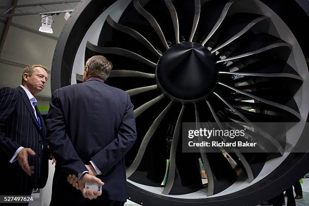 An employee and potential buyer discuss potential business deals at the General Electric jexhibition stand during the Farnborough Airshow. The et...