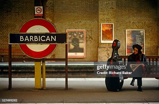 Lady musician is seated at Barbican underground station in central London. The platform is actually above ground and the woman sits patiently...