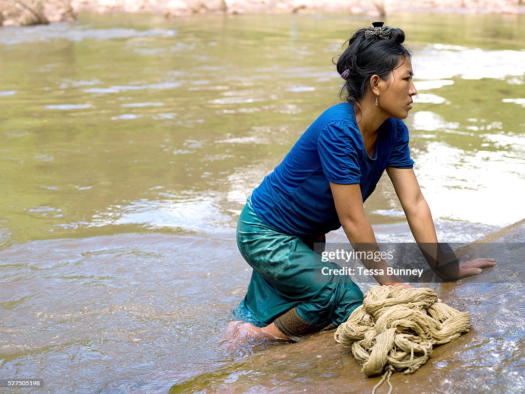 Lao PDR - Ethnic minorities - A Hmong woman washing hemp yarn in the river