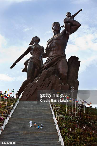 Family running up the steps leading to the African renaissance statue, Dakar, Senegal. An enormous mound of bronze, rising from the rubble of Dakar....