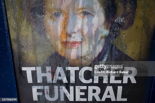 The face of ex-British Prime Minister Margaret Thatcher printed on a newspaper souvenir issue is rain streaked the day after her ceremonial funeral...