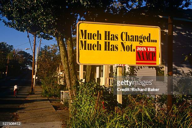 Street sign by the NAACP expressing the view that not much has changed in rights and status for black American people. The National Association for...