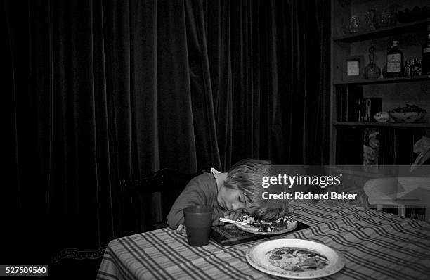 Year-old girl falls asleep before finishing her dinner, the food of which is still on the plate under her head, at home in her south London home. It...