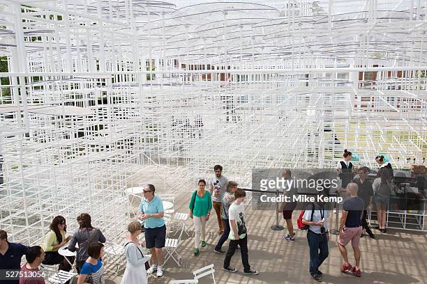 People enjoying climbing up the Serpentine Pavilion 2013 by Japanese architect, Sou Fujimoto. London, England, UK. He is the thirteenth and, at 41,...