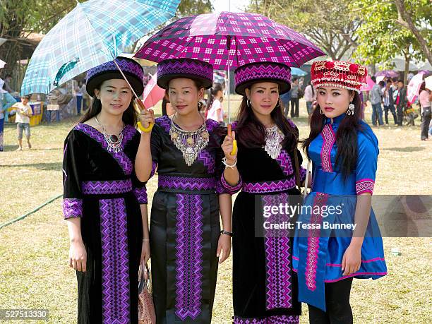 Portrait of four young Hmong Der women wearing contemporary Hmong traditional costume at Ban Km 52 Hmong New Year festival, Vientiane province, Lao...