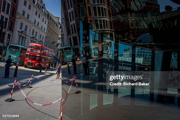 Londoners seen reflected in multiple plate glass windows on a busy summer lunchtime, in the Square Mile, the capital's historic financial district....