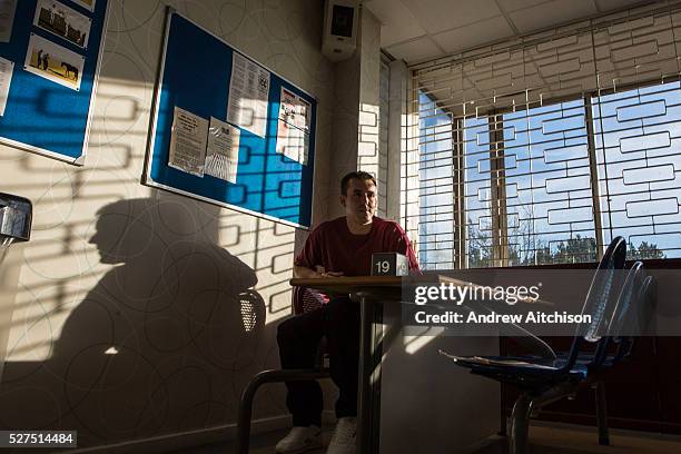 Prisoner sitting in the visit hall waiting for his family to arrive. HMP/YOI Portland, Dorset. A resettlement prison with a capacity for 530...