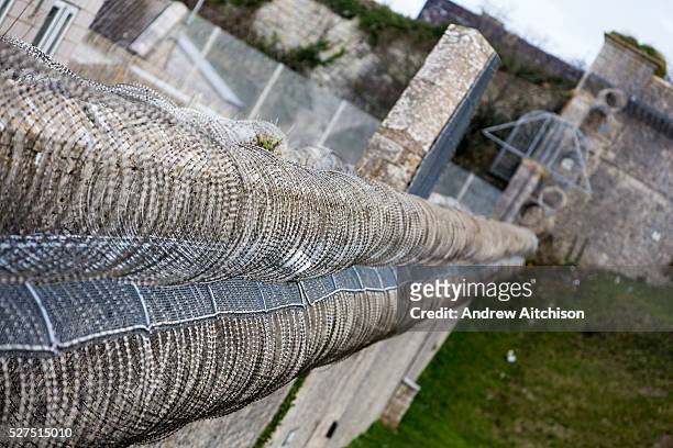 Football stuck in security fencing inside HMP/YOI Portland, a resettlement prison with a capacity for 530 prisoners. Dorset, United Kingdom.