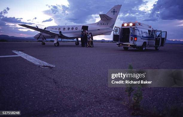 Loading a patient bound for hospital for treatment, on to a British Aerospace BAe-3101 Jetstream 31, an air ambulance on the runway at San Carlos...