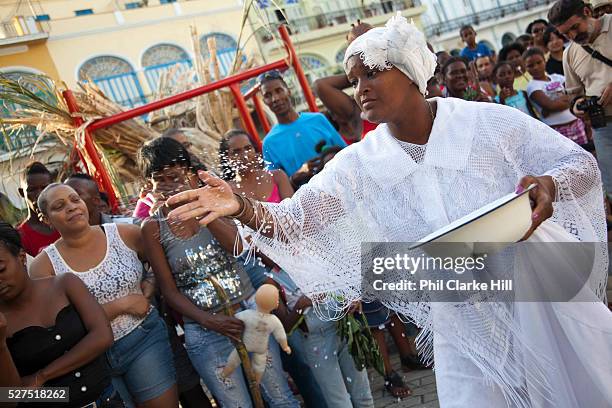 Cuban woman of African descent throwing rice to the crowd in a traditional gesture. Performance in Havana old town, local dance and theatre group...