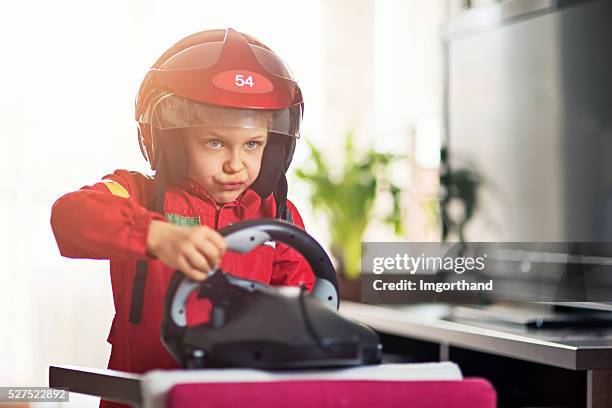 livingroom race - little boy pretending to ride race car - boy kid playing cars stock pictures, royalty-free photos & images