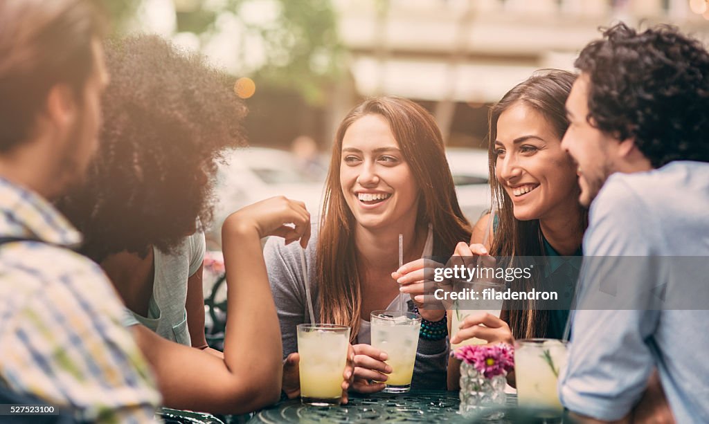Grupo de amigos conversando e rindo no café