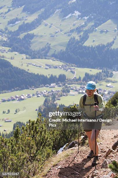 female hiker on mountain trail with grassy valley below - alpbach ストックフォトと画像