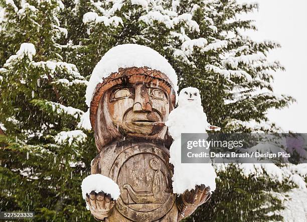 a welcoming totem pole holds a snowman in cowichan bay on vancouver island - cowichan bay stock pictures, royalty-free photos & images