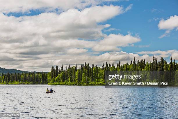 a couple and young girl in a red canoe on byers lake with green forested shoreline, byers lake campground, denali state park - family red canoe stock pictures, royalty-free photos & images