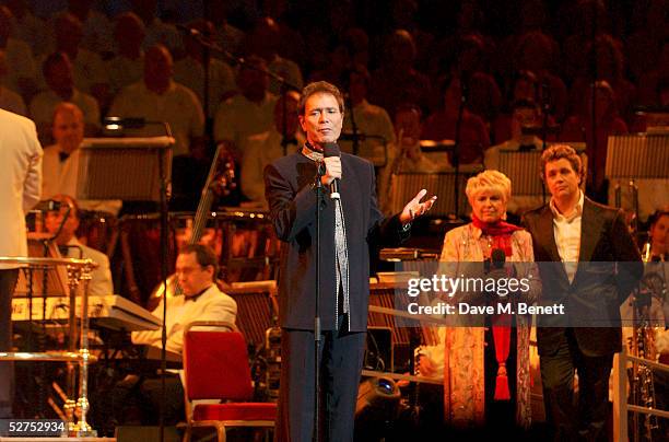 Singer Sir Cliff Richard peforms on stage with Gloria Hunniford and singer Michael Ball at the 'Night of 1000 Voices' at The Royal Albert Hall on May...