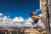 Rock climber clinging to a cliff.
