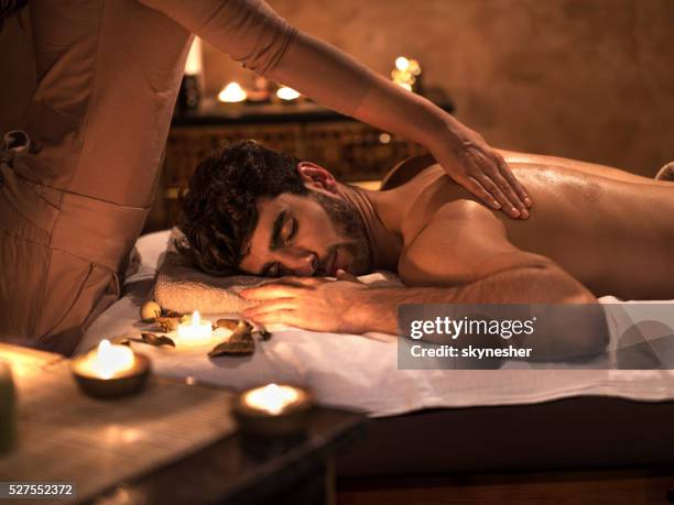 young man enjoying with eyes closed during back massage. - man massage stock pictures, royalty-free photos & images