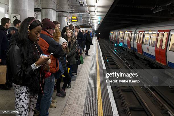 People waiting on the platform at Embankment underground station, London, UK: This public transport tube station is on the District and Circle lines...