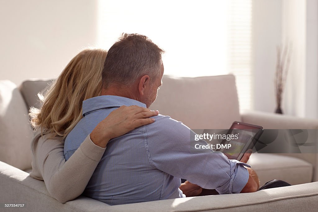 Relaxed mature couple using digital tablet