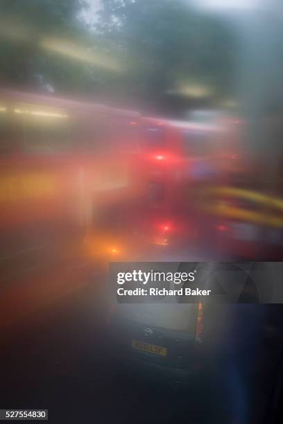 Seen through upper-deck window condensation, buses and traffic during damp, gloomy weather in central London. Low visibility and rain streaks...