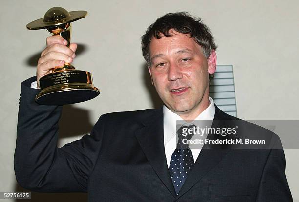 Director Sam Raimi lifts the trophy aloft after being honored during the 31st Annual Saturn Awards at the Universal Hilton Hotel on May 3, 2005 in...