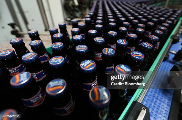 Bottles of Samuel Adams Boston Lager travel along the production line in the bottling house at the Shepherd Neame Plc brewery in Faversham, U.K., on...