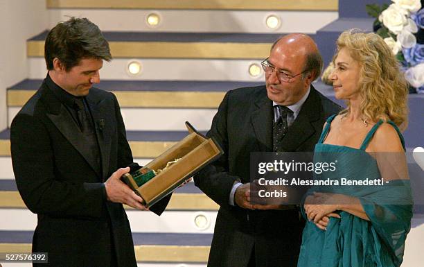 American actor Tom Cruise receives an honorary award from Italian art design Oscar winners Dante Ferretti and his wife Francesca Lo Schiavo, during...